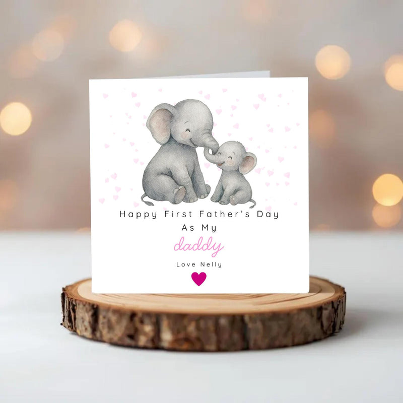 May include: A white Father's Day card with a watercolour illustration of two grey elephants, one large and one small, touching trunks. The card reads "Happy First Father's Day As My daddy Love Nelly" with pink hearts.